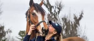 A KER intern posing with a research horse at the KER Performance Center.