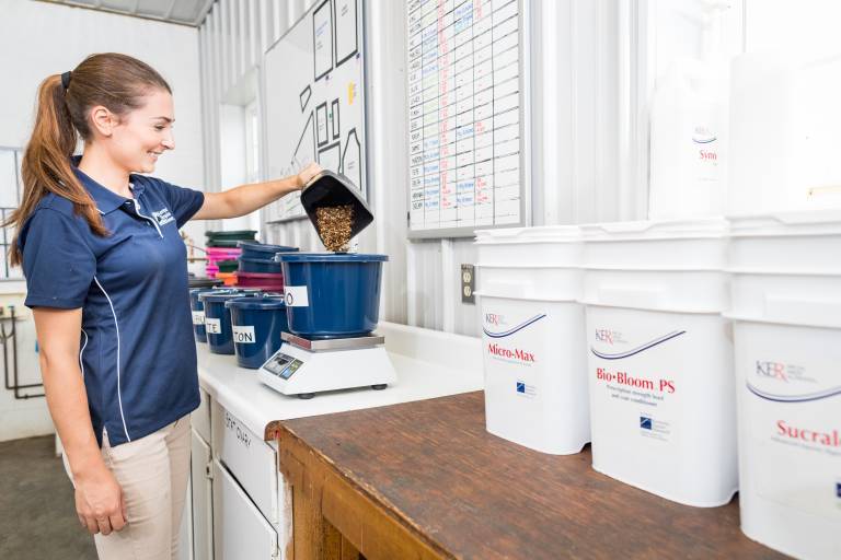 Woman measuring feed into bucket